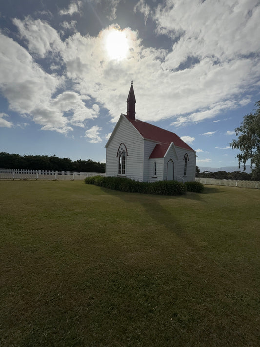 Rural New Zealand Church with Sun and Clouds over it 
